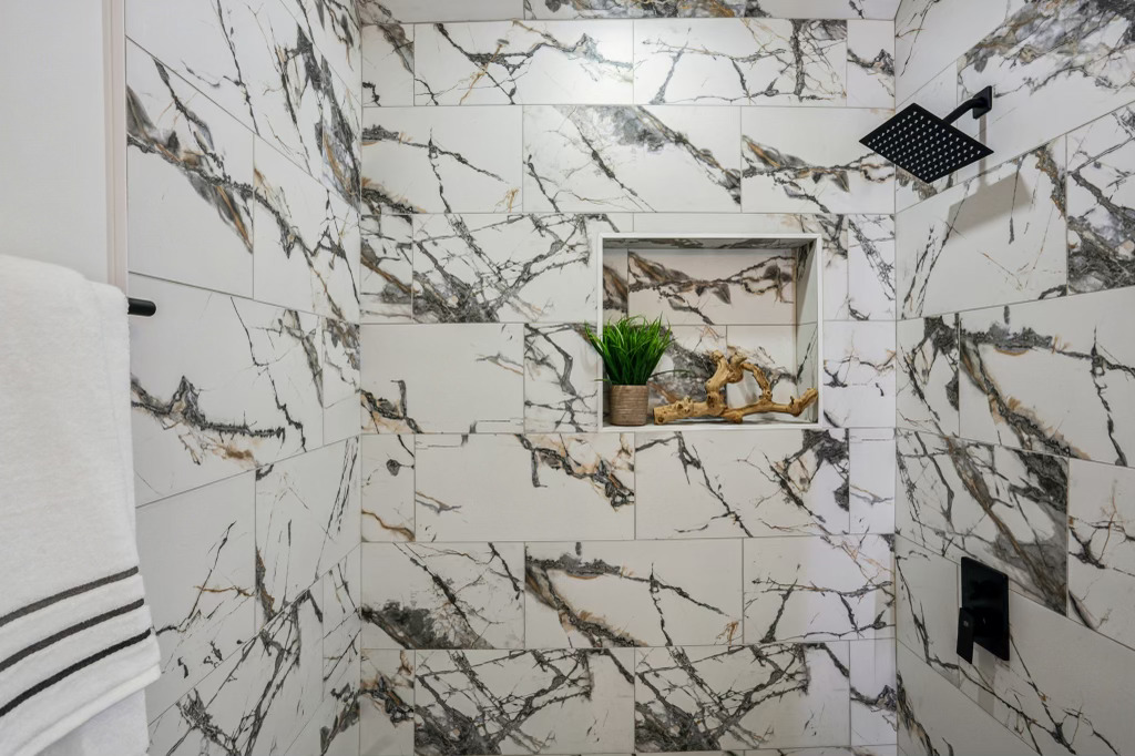 Spalding — book-matched marble running the full height of the shower